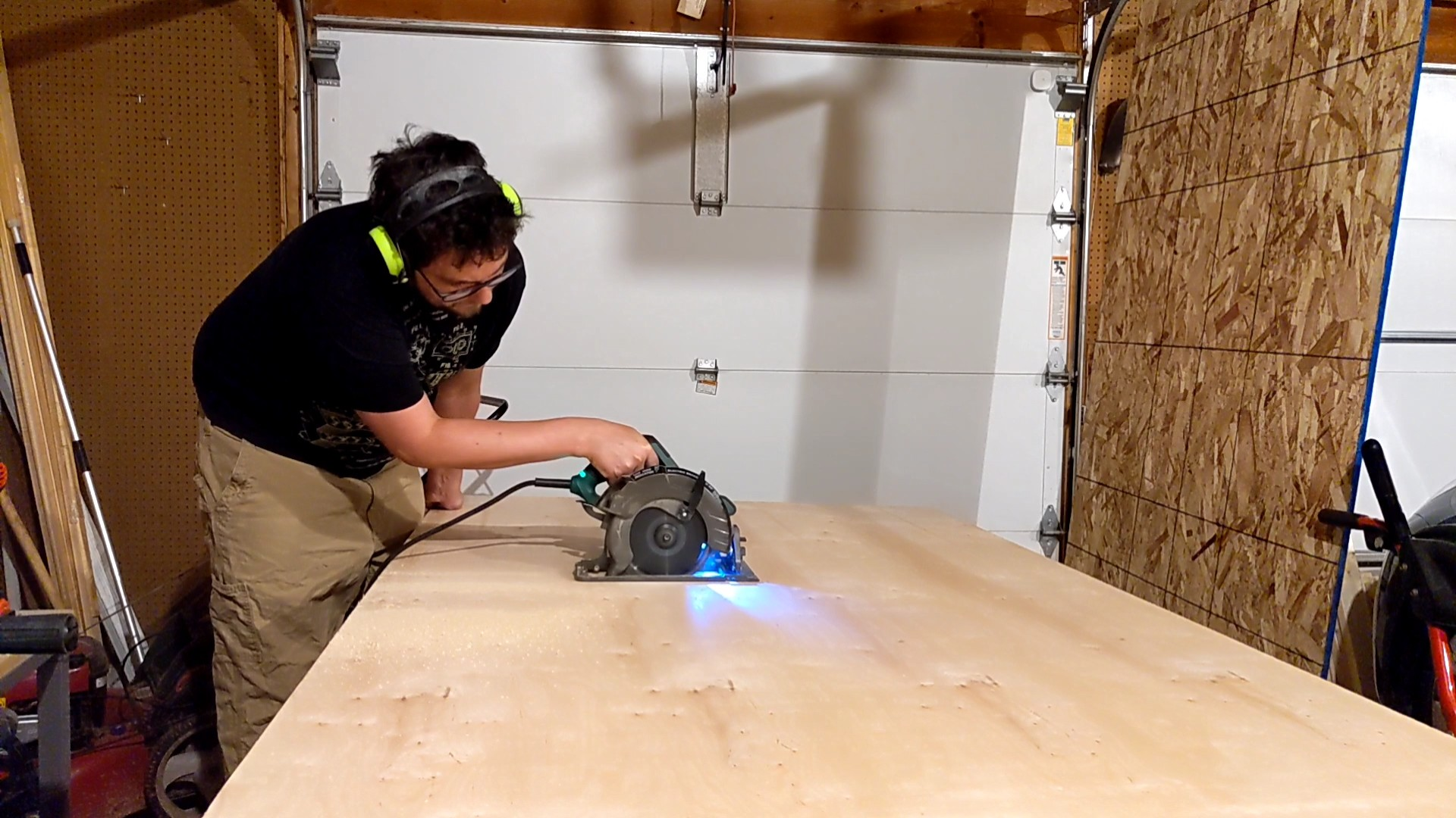 A man using a circular saw to cut plywood