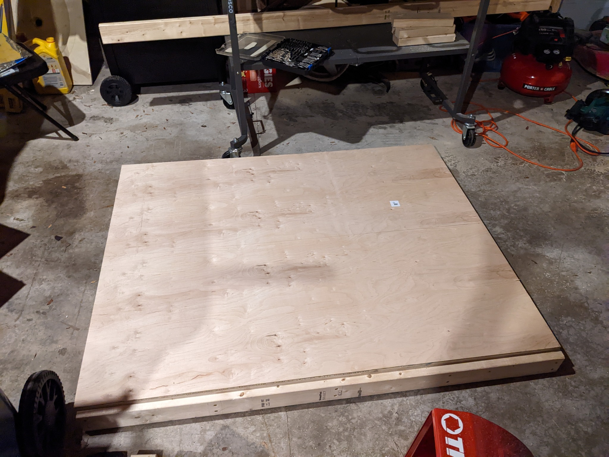 Plywood on top of table frames. A line is drawn down the center