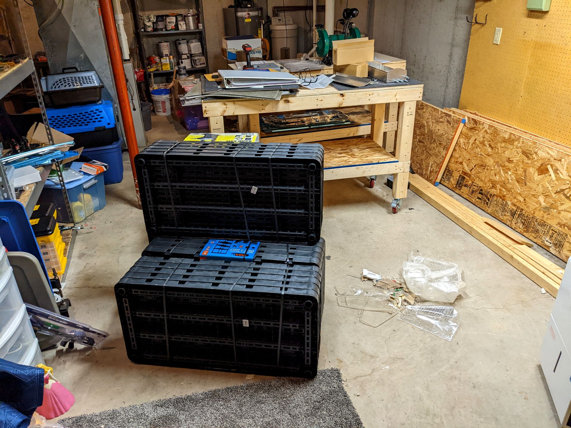 Shelving units in a pile, some messy workbenches, a pile of garbage, and an empty pegboard