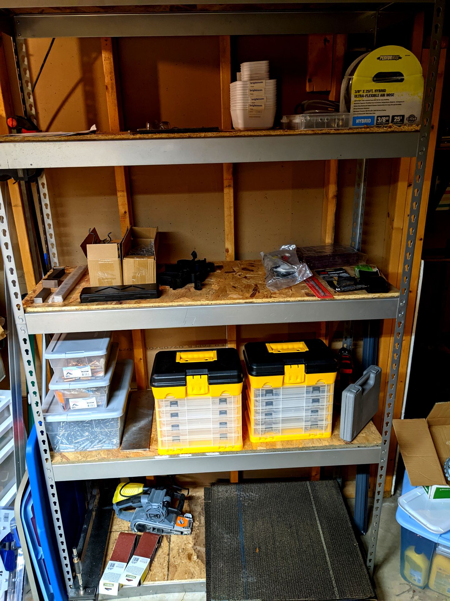 Shelves with various odd shaped tools, bins, belt sander, etc