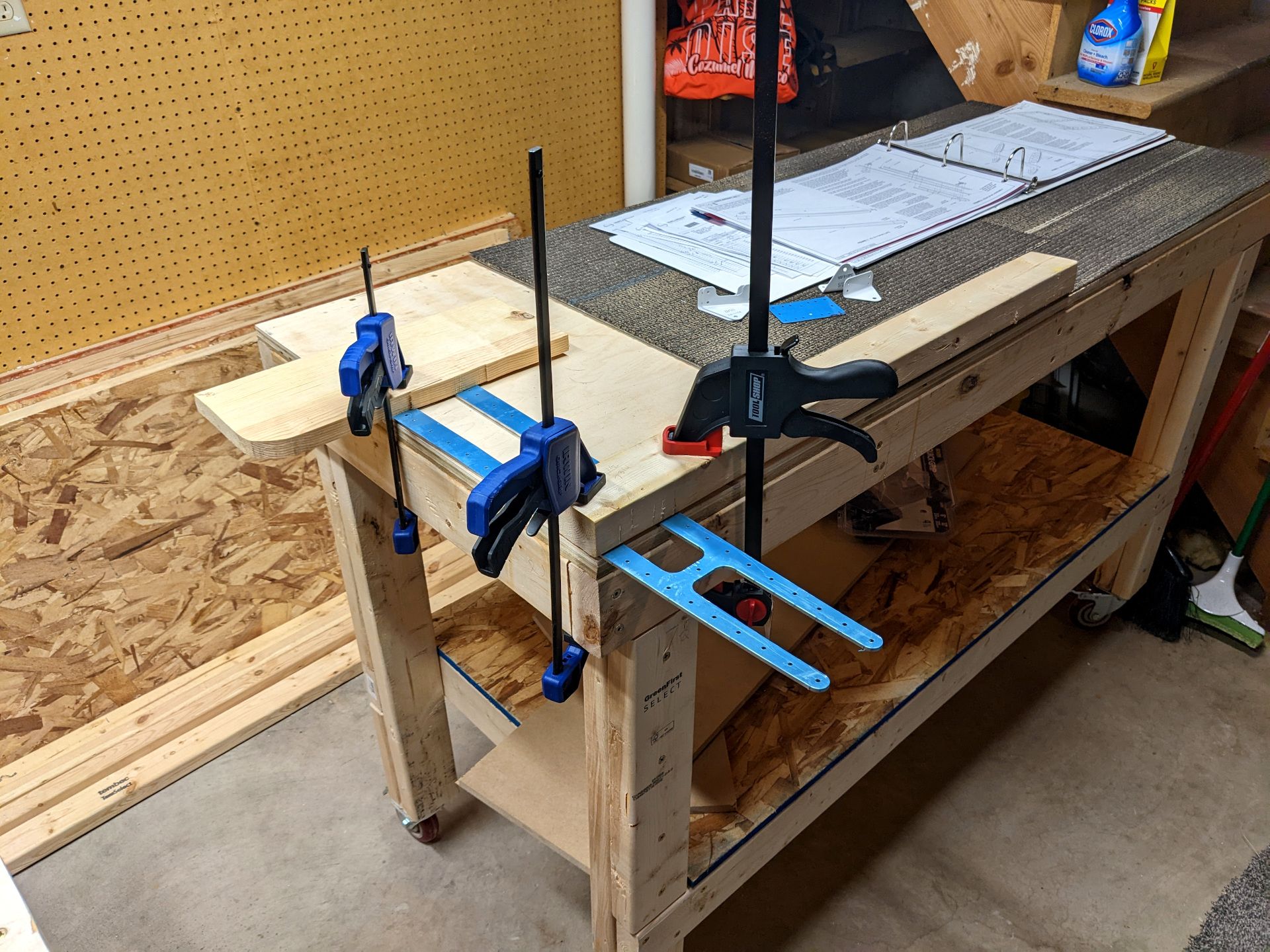 Warped metal part clamped down to table with wood