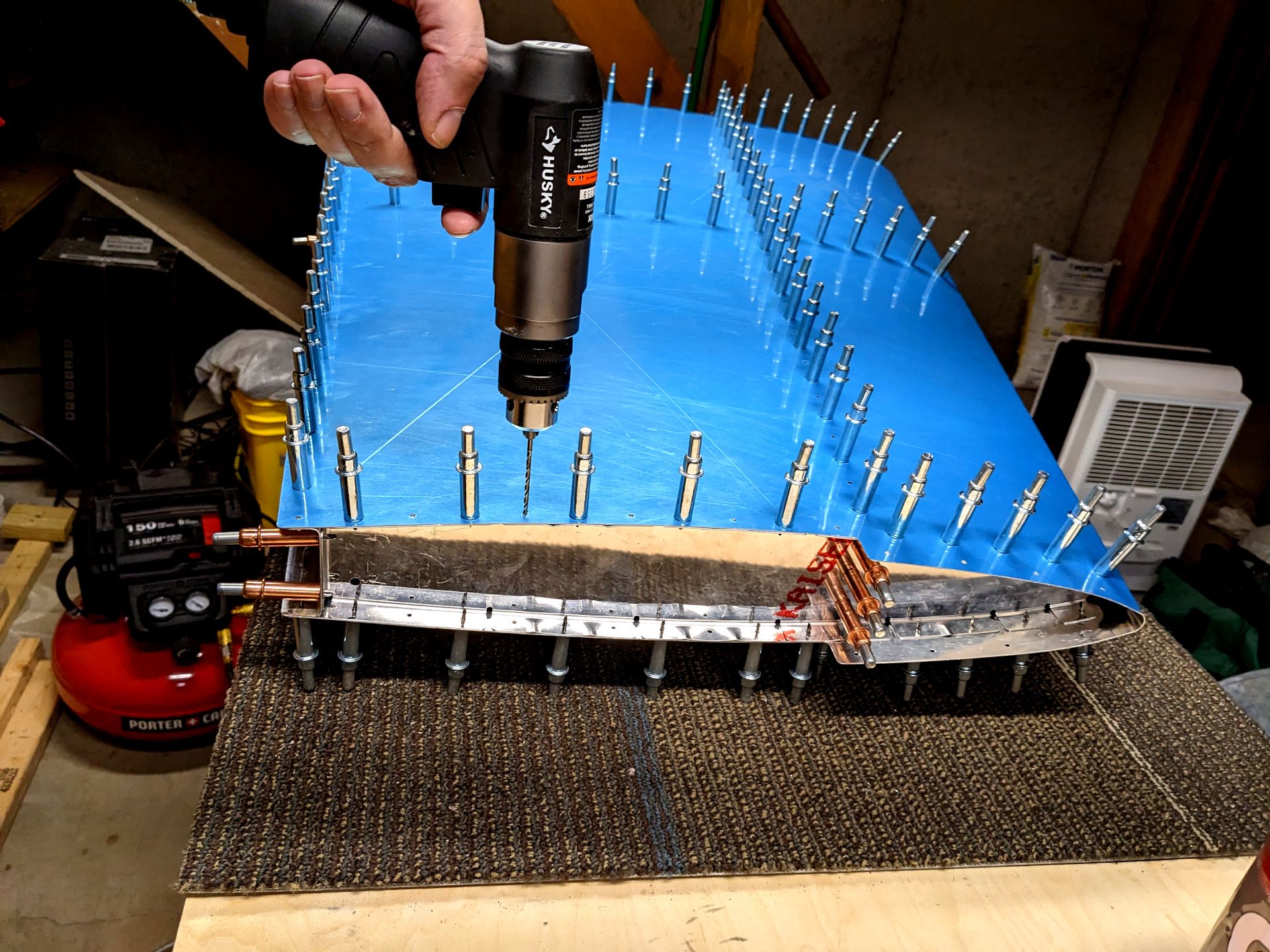 An air drill going through each and every hole on the vertical stabilizer skeleton