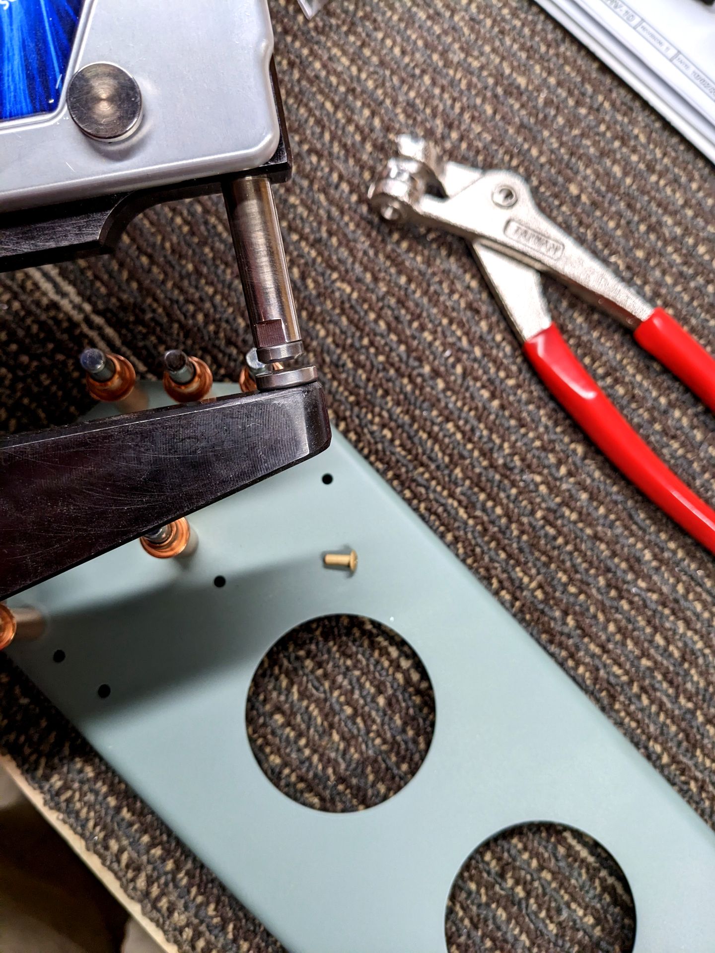 Rivet squeezer yoke in foreground with rivet in background