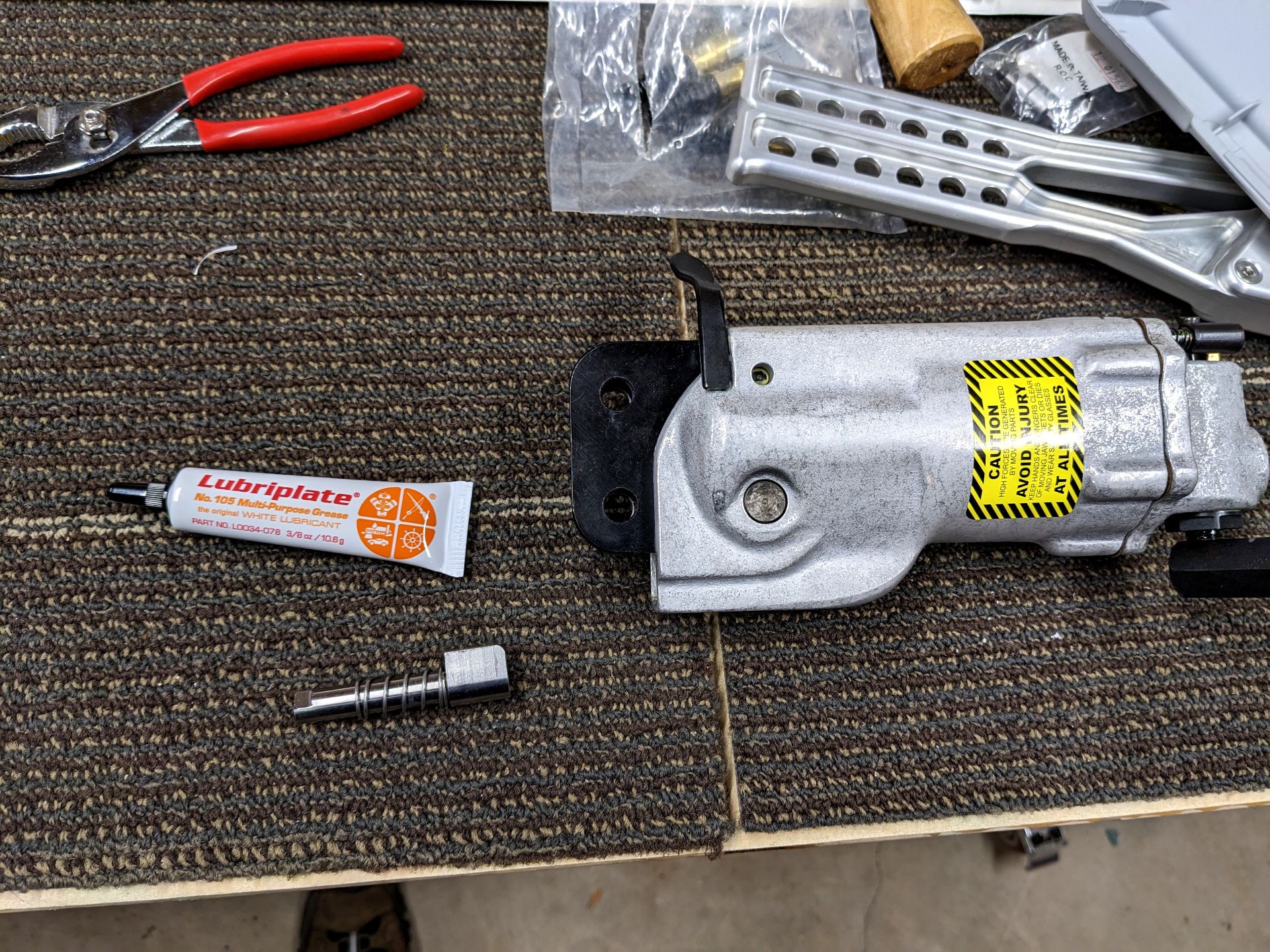 A pneumatic squeezer tool, the ram, and some grease